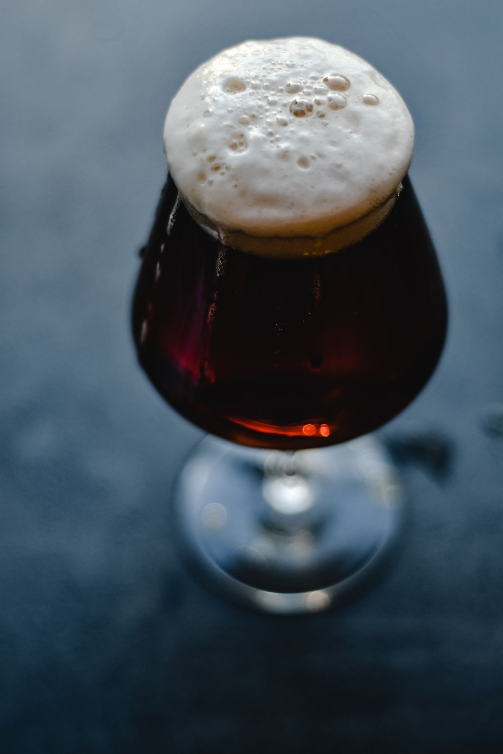 Glass of beer on a dark bar